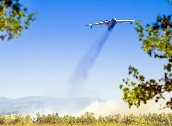 Gökyüzünde dört motor ağır kargo uçağı. Yangınları söndürmek için uçak. Büyük su deposu içinde. Yangına su deşarj