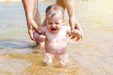 Donmuş ve ağlayan bir çocuk suya oturma. Rekreasyon, tatil, tatil