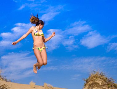 Çekici kız Bikini Beach sahip eğlenceli, yaz tatili atlamayı tatil yaşam tarzı. Mutlu kadın özgürlük kum üzerinde atlama.