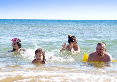Aile üzerinde Beach suyun içinde yalan ve birbirlerinin şirket zevk tatil yaz. Mutlu aile tatil kavramı