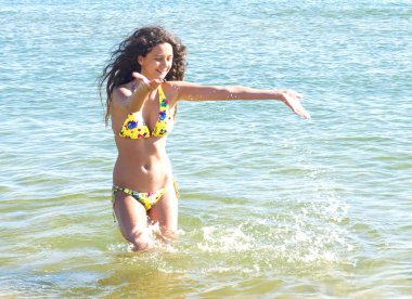 Çekici kız sahil üzerinde eğleniyor. kız yaz mayo denizde