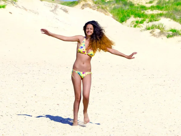 deniz kıyısı üzerinde rahatlatıcı bir sarı bikini koyu lüks saçlı kız moda açık yaz fotoğrafı