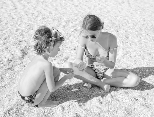 Familie plezier op het strand voor het verzamelen van schelpen. zwart-wit foto — Stockfoto