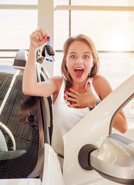 Genç beyaz araba yakınındaki mutlu kadın elinde tuşları ile heyecanlı