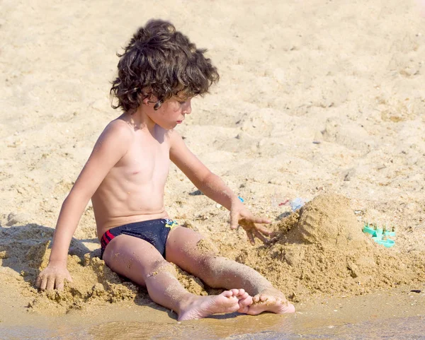 Kleiner Junge Baut Sandburg Strand — Stockfoto