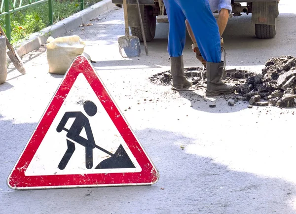 Yol çalışmaları inşaat yol inşaat trafik işareti altında kayıt. Trafik, uyarı işareti yol tamiri. Kırmızı, siyah üçgen yol işareti işçisi çekiç asfalt arka plan üzerinde matkap ile çalışmak
