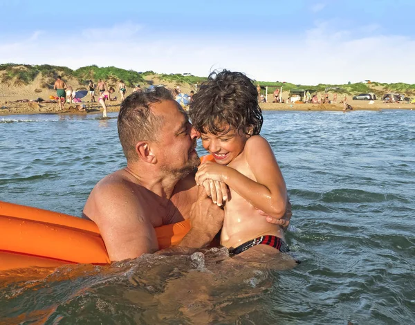 Portret van een gelukkig vader met zijn zoontje op vakantie. — Stockfoto