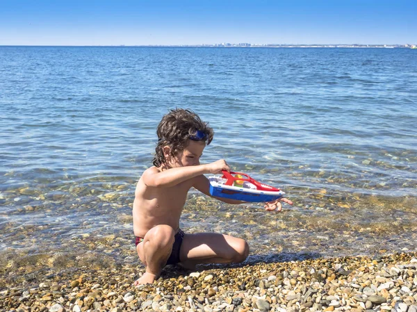 Denizde Bir Oyuncak Gemi Ile Oynayan Mutlu Çocuk — Stok fotoğraf