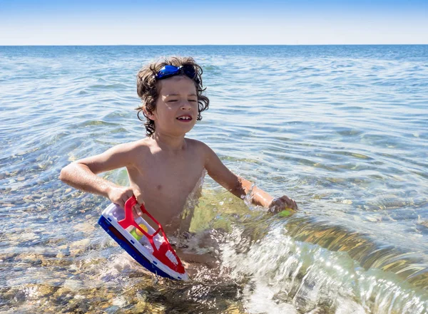 Bambino Felice Che Gioca Con Una Nave Giocattolo Nel Mare — Foto Stock