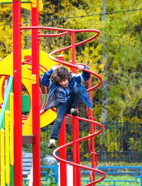 Çocuk Bahçesi sonbaharda eğleniyor. Modern renkli Bahçesi sıcak bir günde. Çocuklar moda. Çocuklar faaliyetleri. Sonbahar tatil. Açık oynayan sevimli çocuk. Sıcak mavi bir ceket giyen çocuk.