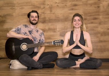 Yeni evliler yoga meditasyon. Gitar çalıyor, kadın asana egzersizleri yapıyor adamım.