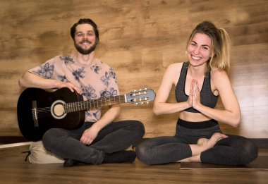 Yeni evliler yoga meditasyon. Gitar çalıyor, kadın asana egzersizleri yapıyor adamım.