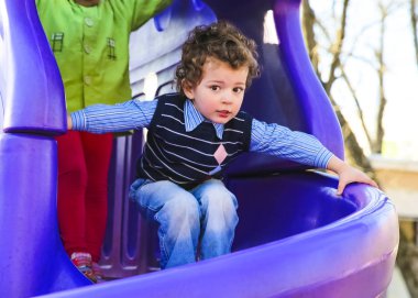 Eğleniyor çocuk parkta aşağı kayan. açık havada oynayan çocuk. metniniz için kopya alanı