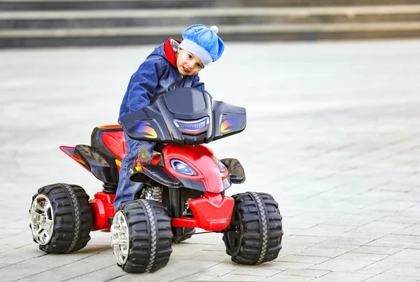 Brunette Boy Rides Electric Red Car City Park — Stock Photo, Image