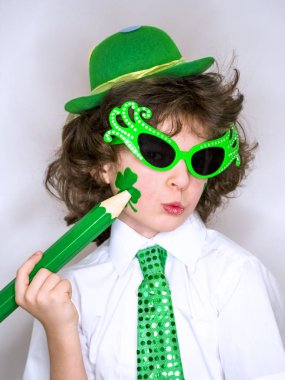 Komik St Patricks günü yeşil bir şapka giymiş küçük çocuk çarpıcı. Kendini ifade. Genç çocuk kendisi üzerinde büyük yeşil pencil.light arka planı olan bir yonca çizim.