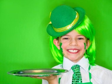 Komik St Patricks Günü elinde bir yeşil şapka ve yeşil giymiş bir tepsi ile küçük çocuk peruk gülümseyen kameraya bakıyor. Green.Copy alanı izole
