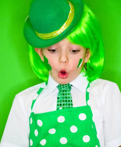 有趣的圣帕特里克日小男孩戴着绿色的帽子和绿色的假发震惊与张大的嘴向下看 隔离在绿色 — 图库照片