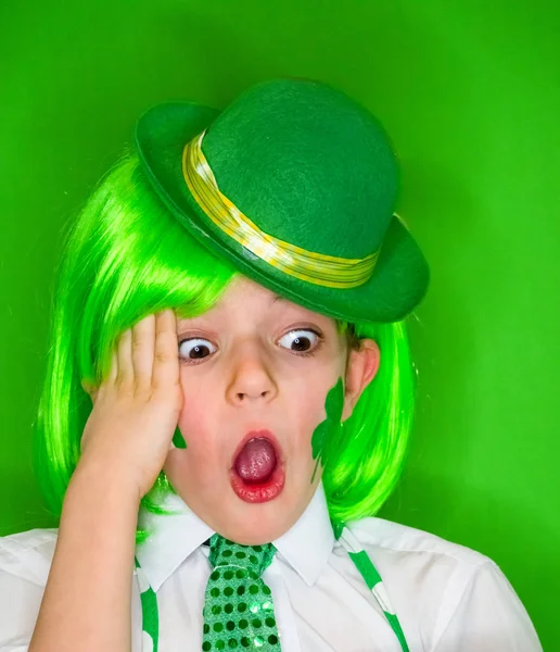 有趣的圣帕特里克日小男孩戴着绿色的帽子和绿色的假发震惊与开放的嘴 隔离在绿色 — 图库照片