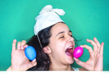 Kadın holding yumurta. Paskalya bunny kulaklar bir sürpriz yüz, korkuyor ve heyecanlı korku ifadesi ile şok korkmuş giyen genç esmer kadın