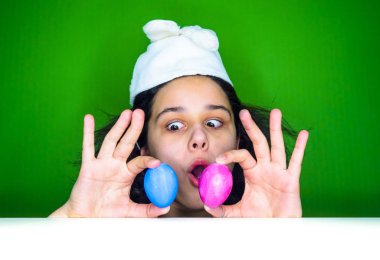 Kadın holding yumurta. Paskalya bunny kulaklar bir sürpriz yüz, korkuyor ve heyecanlı korku ifadesi ile şok korkmuş giyen genç esmer kadın