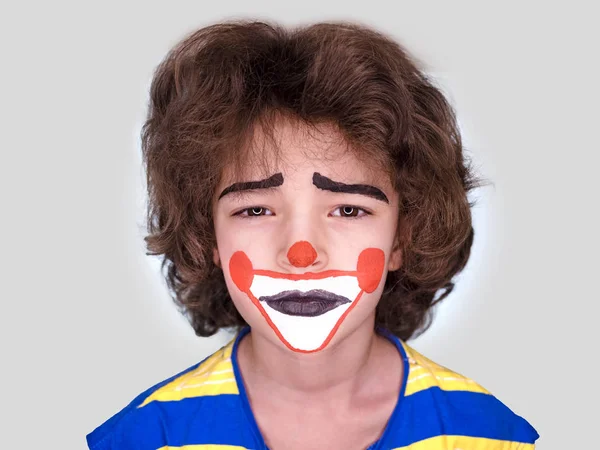 Милий хлопчик з facepaint як клоун, pantomimic вираз. Хоп, 1 квітня. Ізольовані на сірий — стокове фото