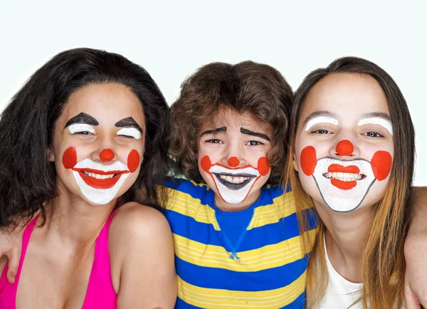 Twee tiener zusjes en een broertje in de rol van clowns poseren in de studio — Stockfoto