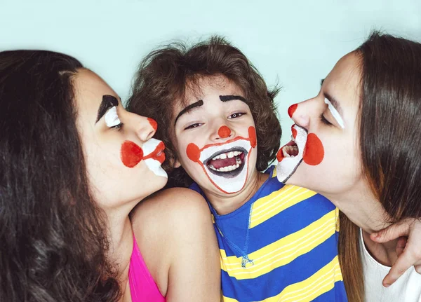 Dos hermanas adolescentes y un hermano pequeño en el papel de payasos posando en el estudio — Foto de Stock