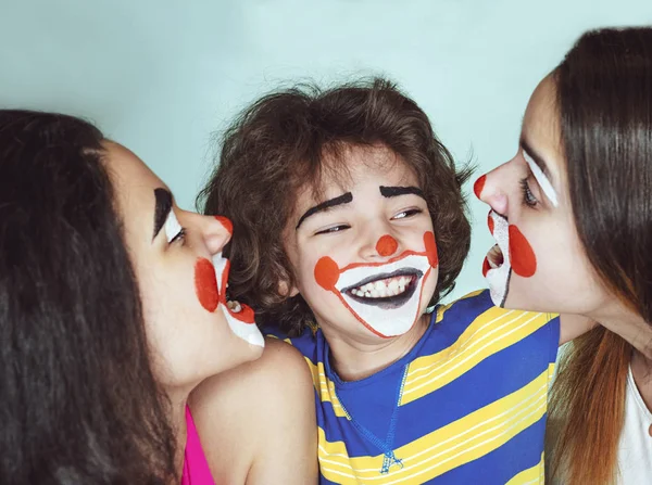两个十几岁的姐妹和一个弟弟在小丑的角色摆姿势在演播室 — 图库照片
