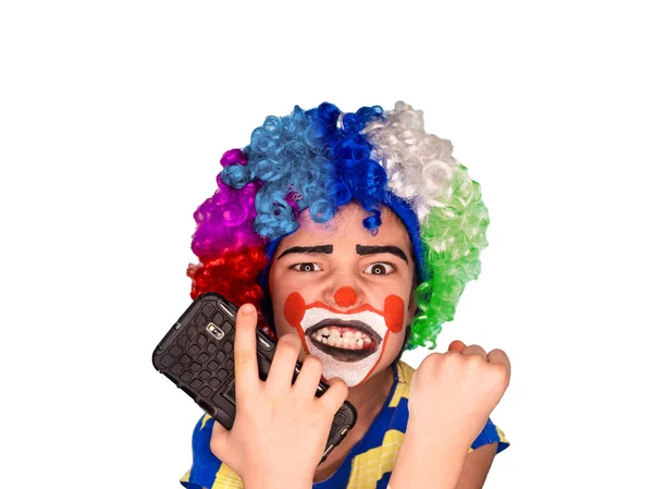 Ritratto di bambino clown divertente felice che tiene smartphone e arrabbiato a causa di cattive notizie. Espressione concettuale negativa ed espressiva.espressione pantomimica. emozioni. April Fool s Day, 1 aprile. Isolato su bianco . — Foto Stock