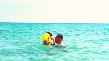 Baba ve oğlu can yeleği yavaş hareket eğleniyor denizde gündüz