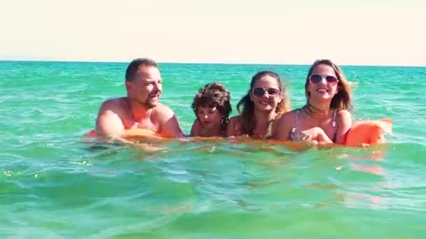 家庭的慢动作与橙色床垫在白天在海上有乐趣 — 图库视频影像