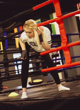 Boks eldivenli boksörde yüzük. Seksi spor sarışın kız Boxer yüzük poz. Fit kadın boks.