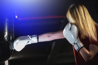 Kadın spor salonunda boks ağır çantasına vurdu. Sert karışık dövüş sanatları eğitimi