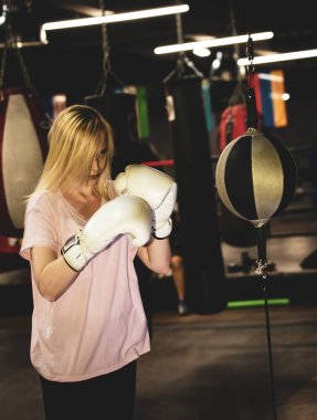 Boksör kadın boks topunda çalışıyor.