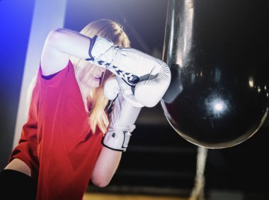 Kadın spor salonunda boks ağır çantasına vurdu. Sert karışık dövüş sanatları eğitimi