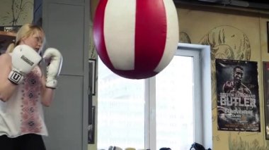 Spor salonunda delme çantası ile güzel sarışın kadın Boxer eğitim 