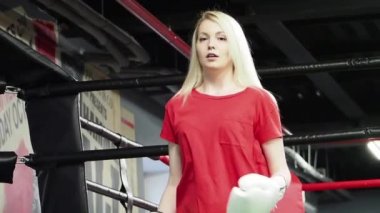 Spor salonunda yüzük at boks eldiven giyen sarışın kadın Boxer 