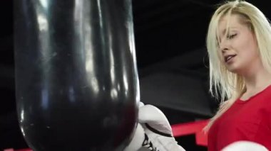 Spor salonunda delme çantası ile güzel sarışın kadın Boxer eğitim 