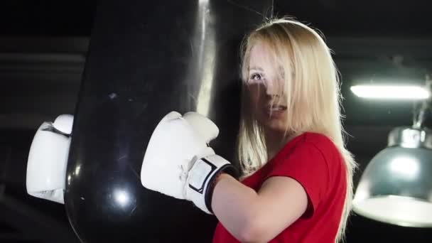 美丽的女拳击手在健身房锻炼 疲惫的汗流满面的女人抱着一个打气筒 — 图库视频影像