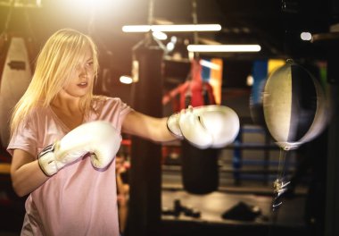 Boksör kadın boks topunda çalışıyor.