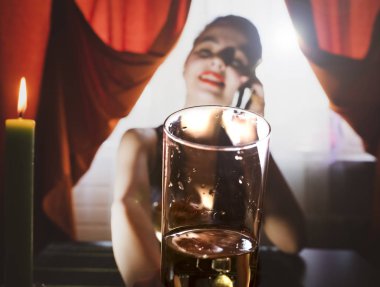 Güzel kız bir bardak şampanya tutan, bir restoranda şampanya içme, bir akşam parlak elbise, bir tarih ya da bir toplantı, kamera içine bakarak ve dokunmaya çalışır. Seçici odaklama