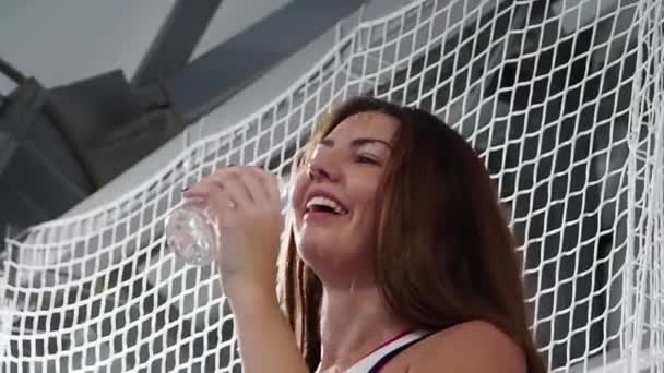 テニスコートでハードプレイした後に水を飲む美人若い女性 スローモーション — ストック動画