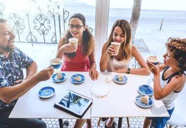 Aile Kafe 'de Atıştırmalık Afiyet Olsun. Kahve dükkanında kahvaltı yapan olumlu aile.