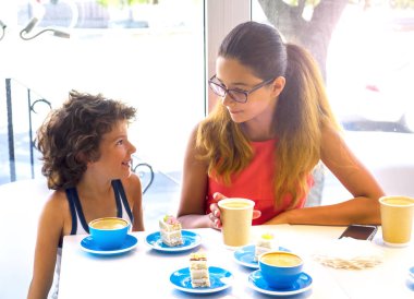 İki Çocuk Kafe'de Dinleniyor. Çocuklar Güzel Genç Erkek ve Kız Kardeş. İnsanlar Bardaklardan Çay İçer.