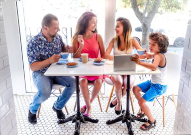 Kahvaltı ve tablet kullanarak mutlu bir aile. Mutlu bir adam ve internet, kullanarak seyir perde için üç çocukları gülümseyen kafe, dijital tablet olan büyük bir şirket online satın