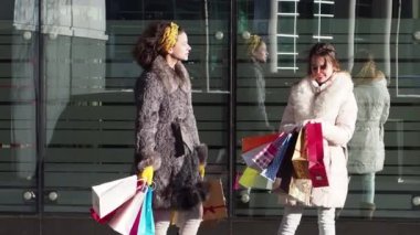 Alışverişten sonra alışveriş, modern şehir arka plan bakarak kış giysileri iki kız. Yavaş çekim
