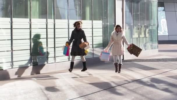 Dos Chicas Ropa Invierno Caminando Aire Libre Con Bolsas Compras — Vídeos de Stock