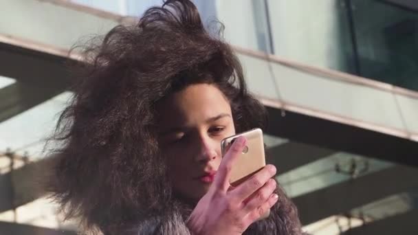 Jonge Krullend Meisje Winterkleren Met Behulp Van Smartphone Mall Achtergrond — Stockvideo