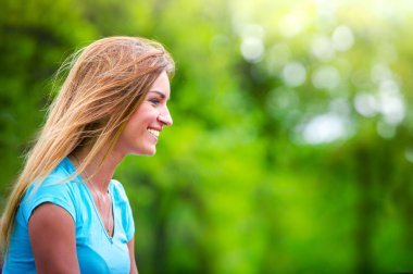 Rüzgar profil yakın çekim güzel kız portresi. Yeşil yaz doğası karşı profilde kız portre. Boşluk Kopyala