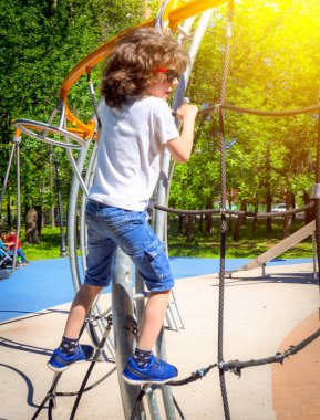 Çocuk oyun ekipmanları oynuyor. Aktif küçük çocuk okul bahçesinde oyun at tırmanma net oynuyor. Çocuklar oyun ve güneşli bir yaz gününde açık havada tırmanmaya